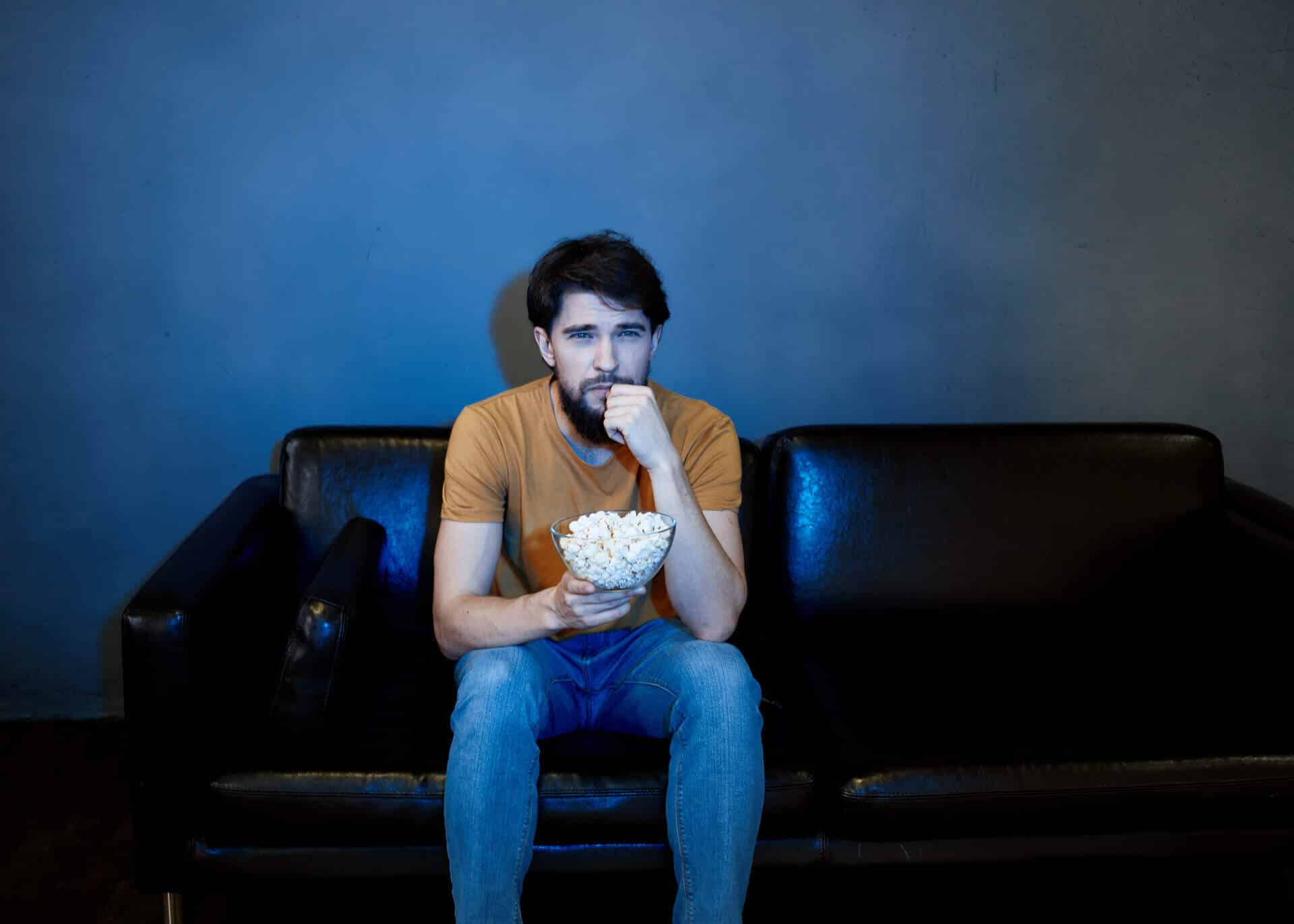 lonely man sitting on couch with popcorn
