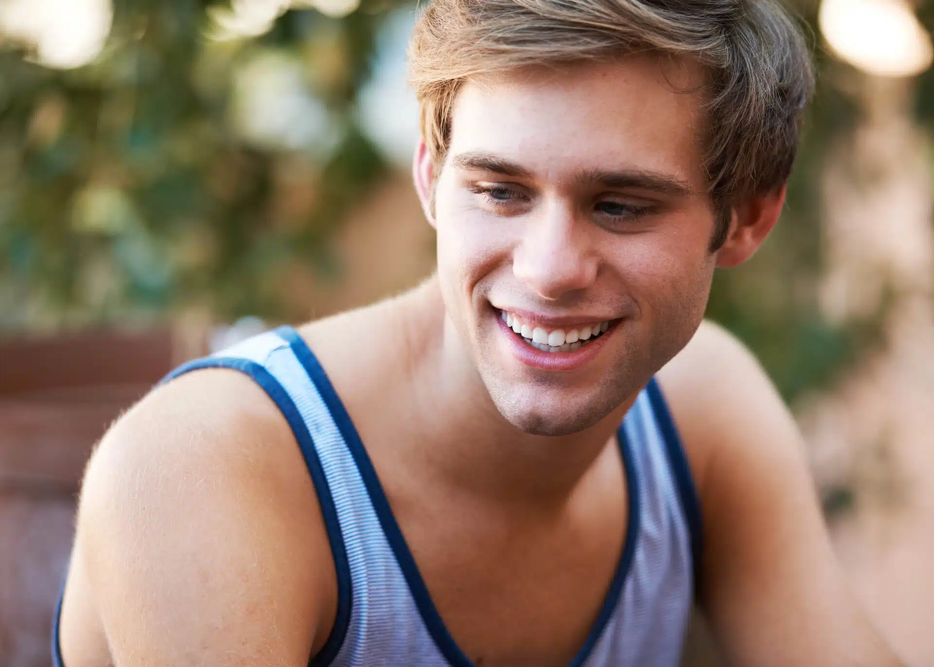 shy young man smiling while looking away