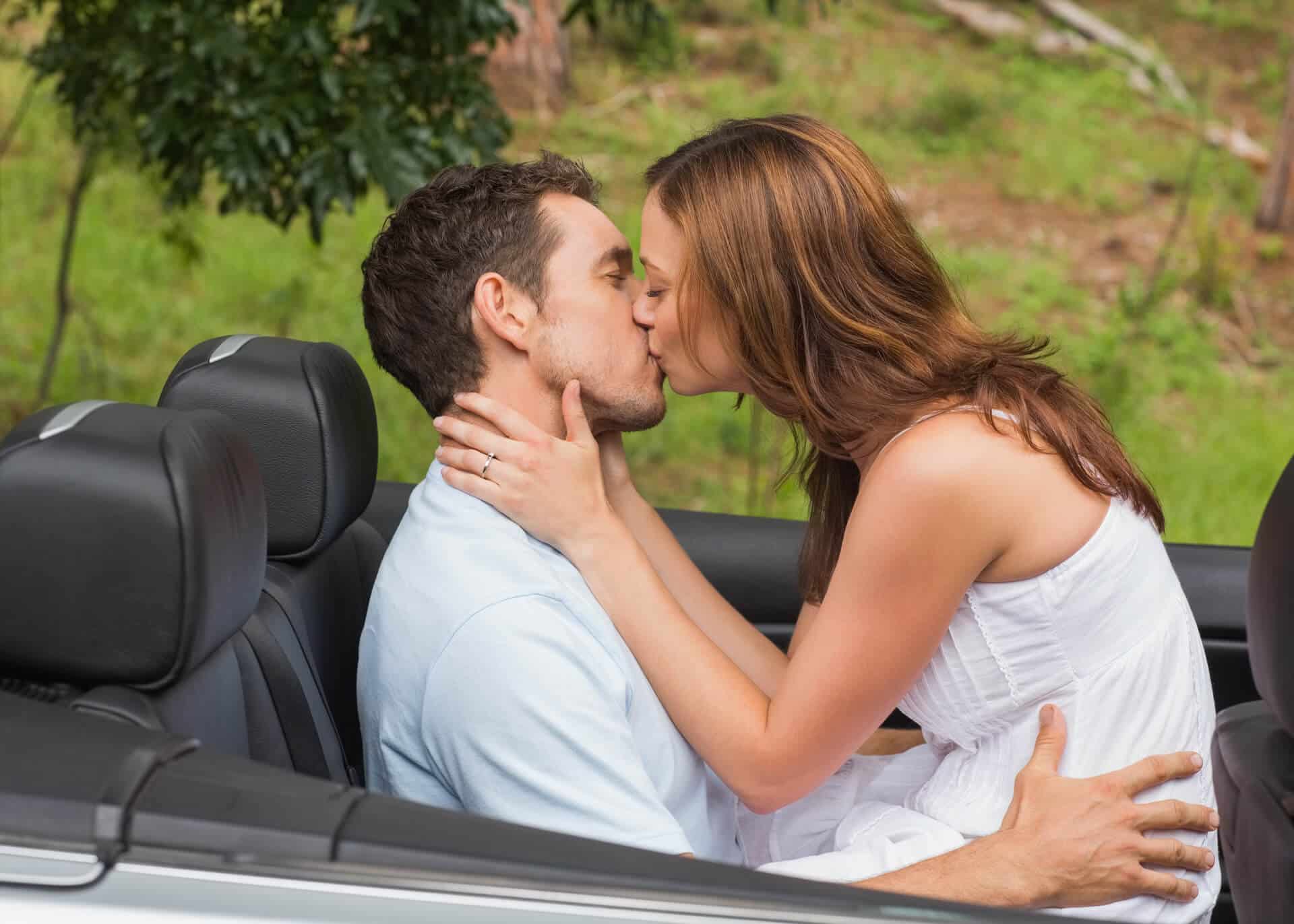 young couple kissing in back seat