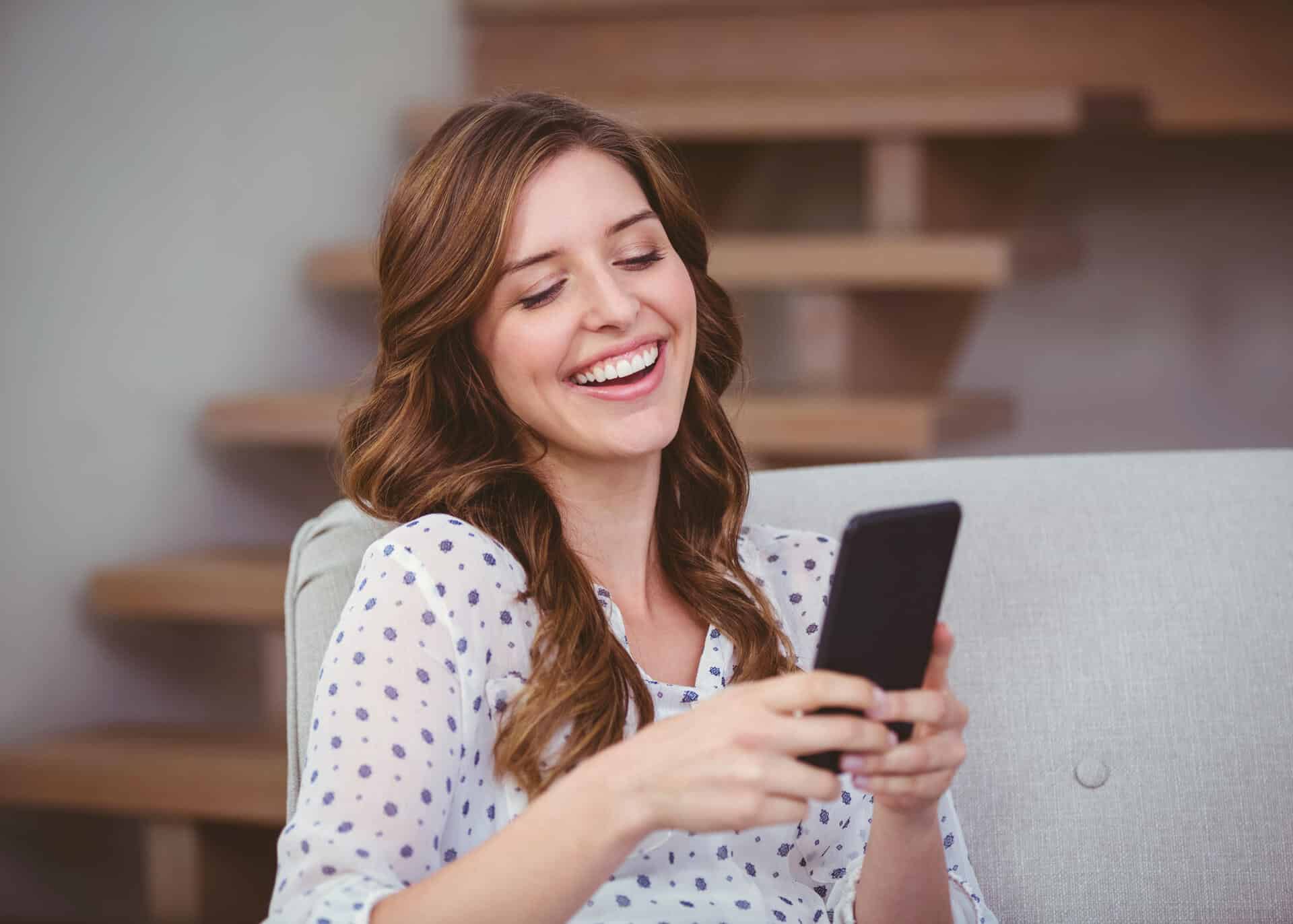 smiling young woman reading text message