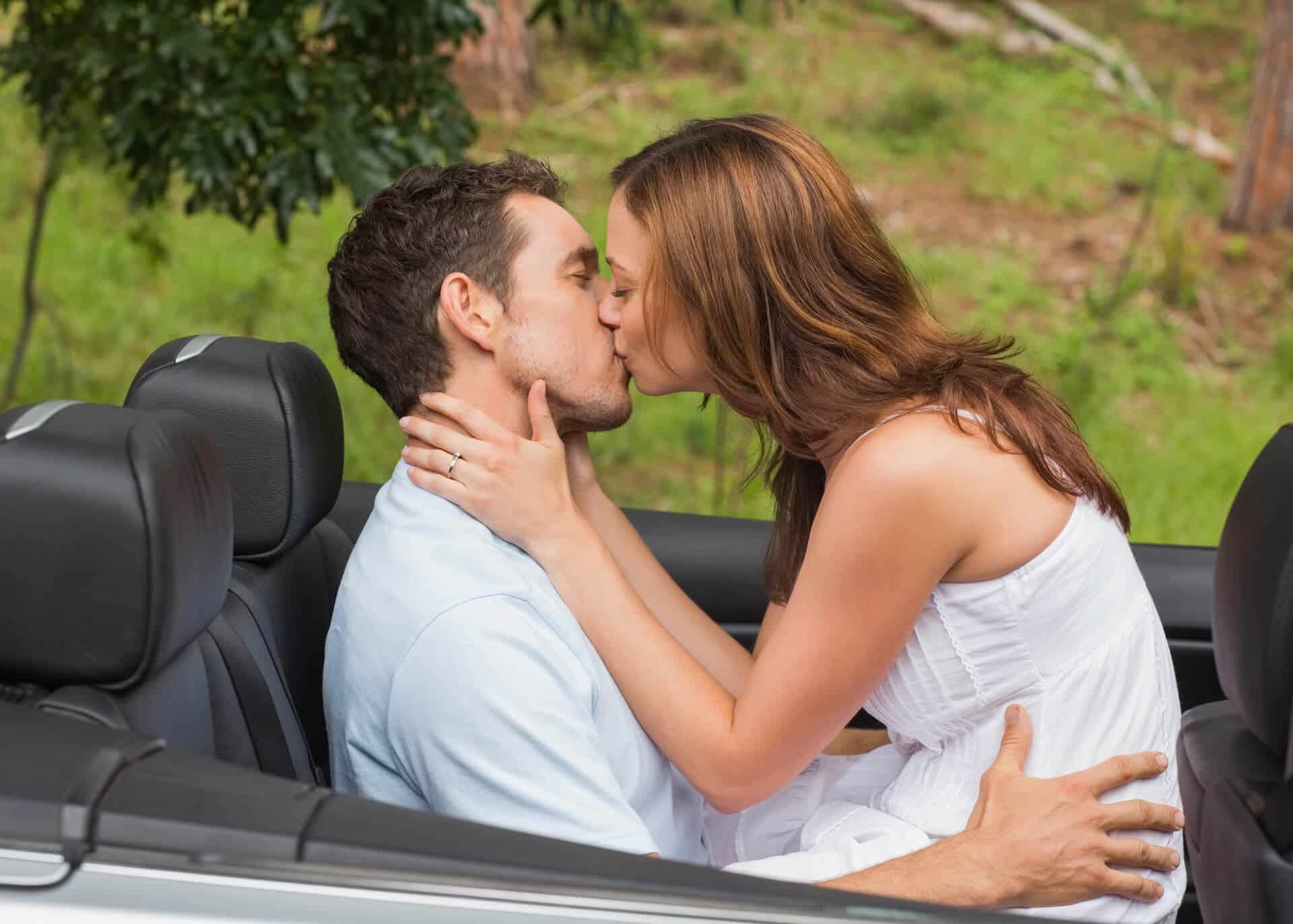 young couple kissing in the back seat of the car