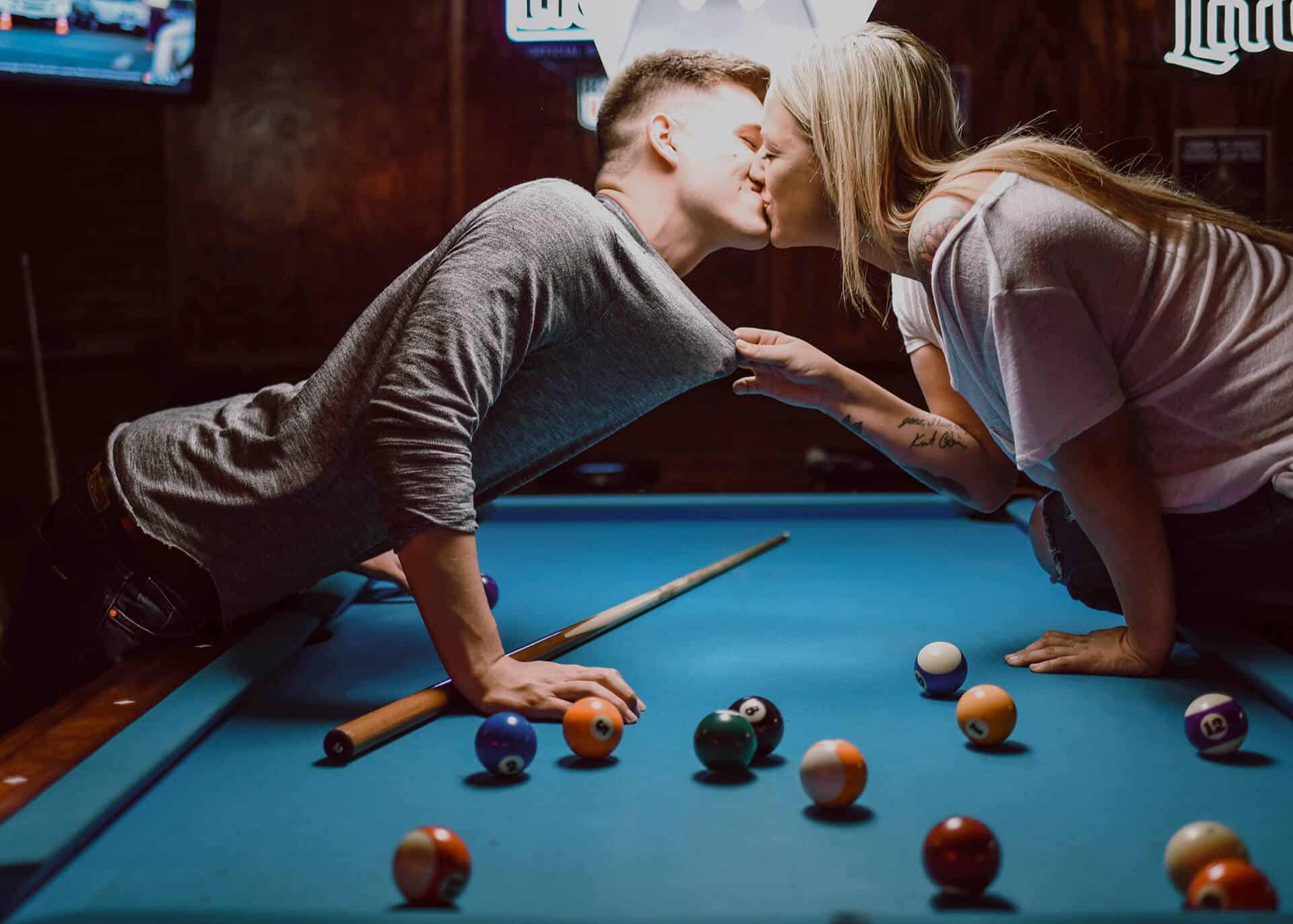 couple kissing over pool table