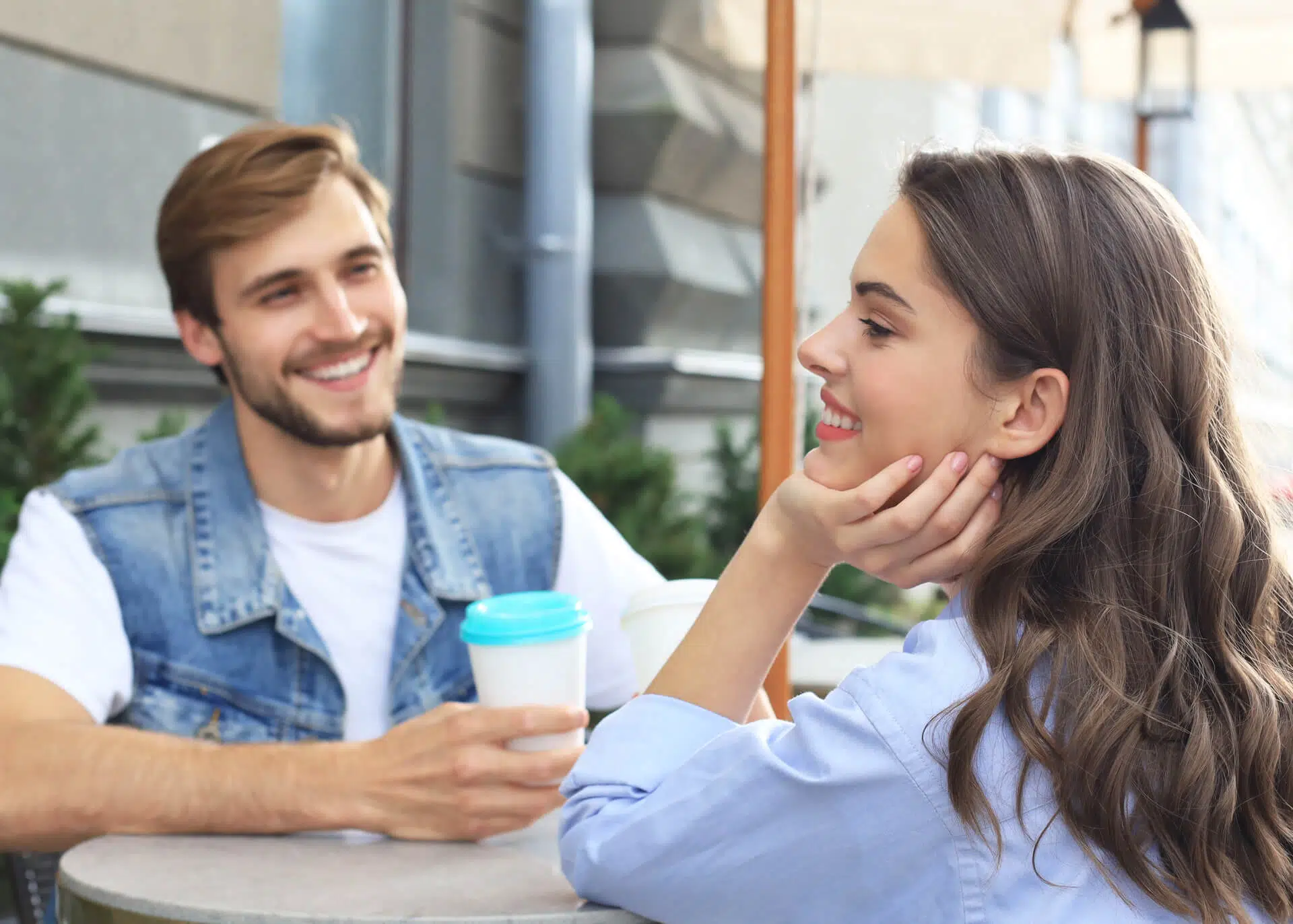 attractive young couple in love drinking coffee outdoors