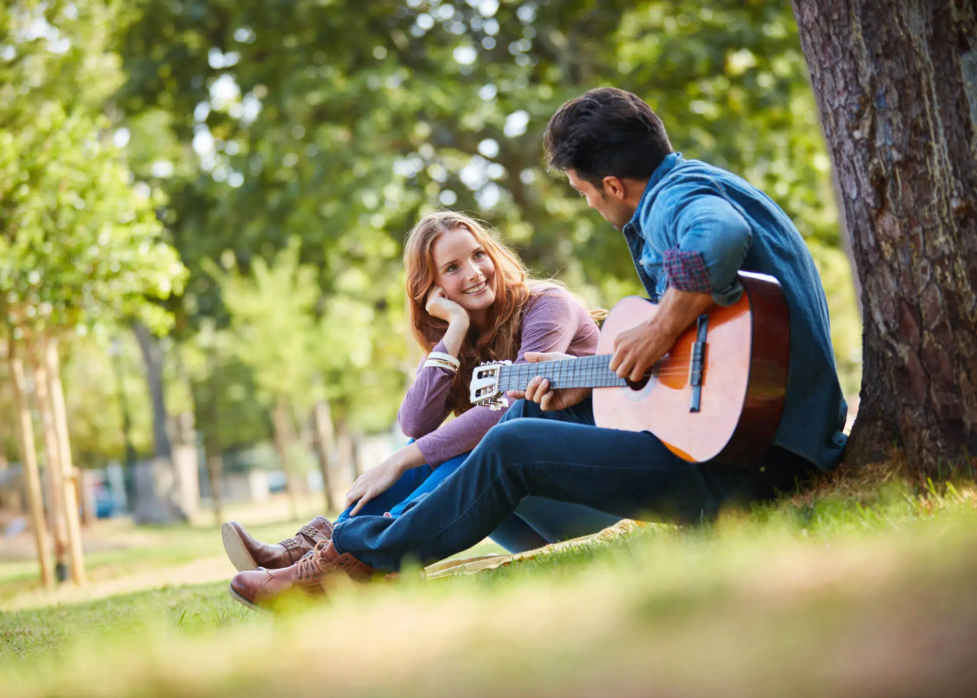 guy singing love song to a girl at the park