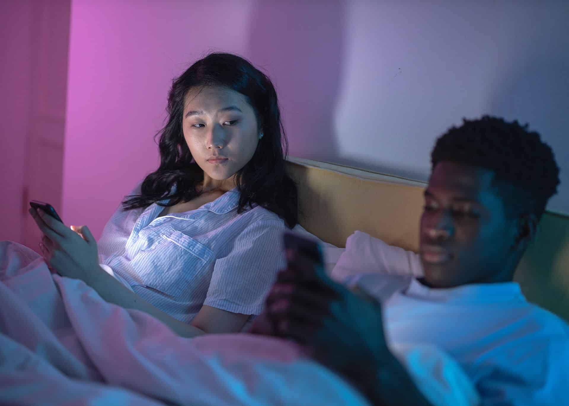 couple in bed with phones