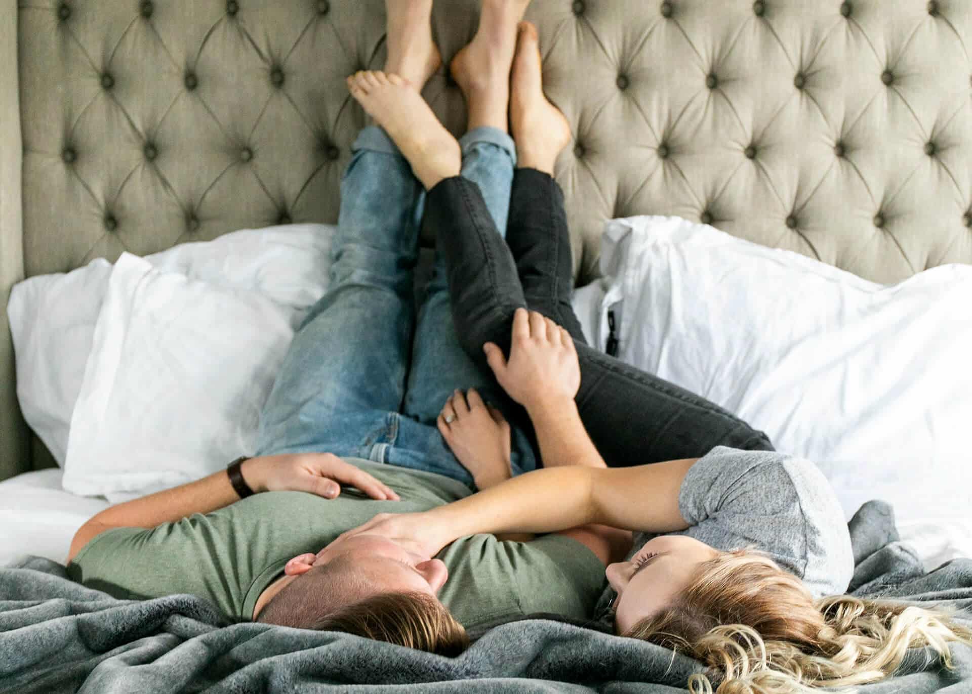 young couple in bed legs up