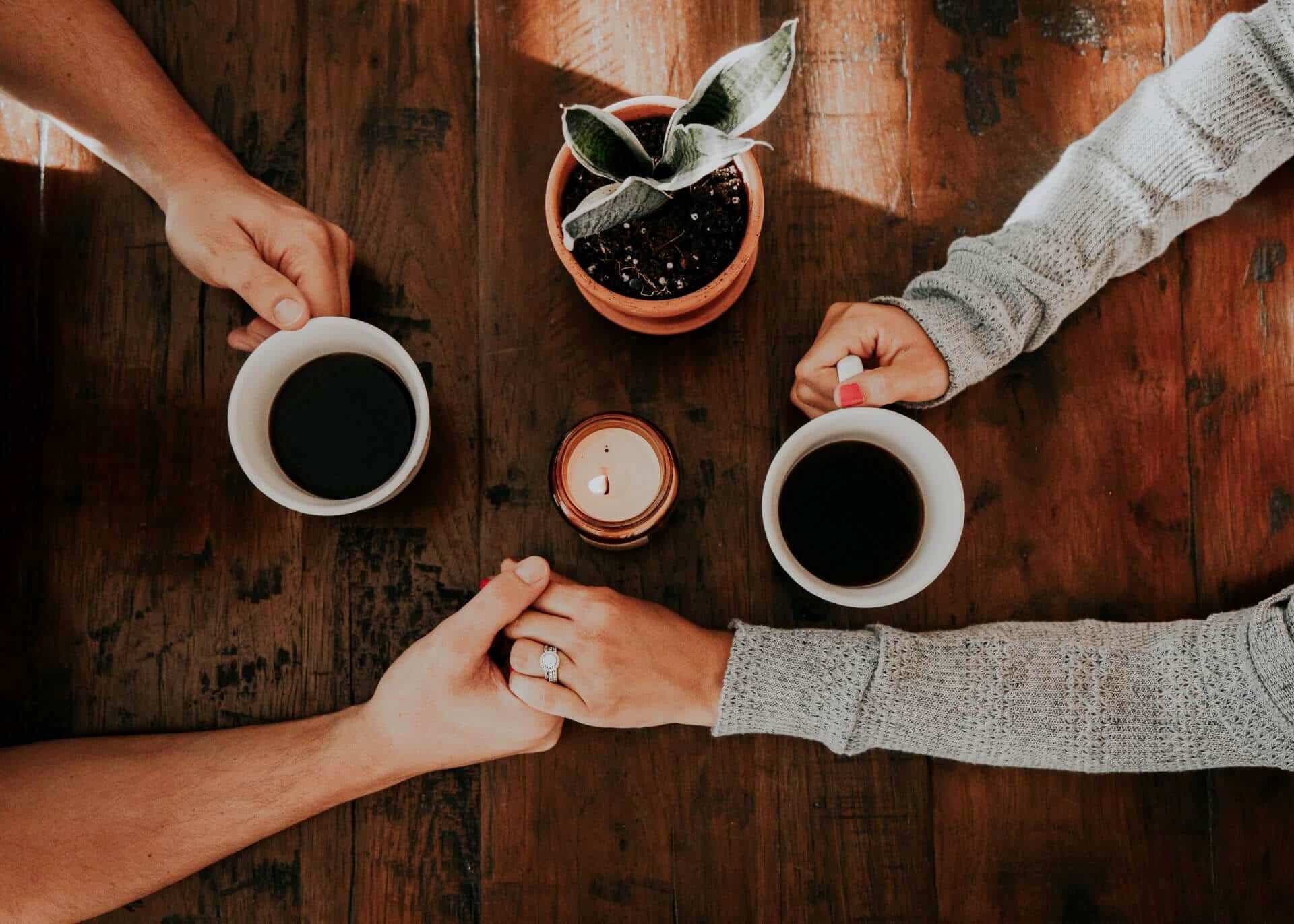 couple drinking coffee holding hands