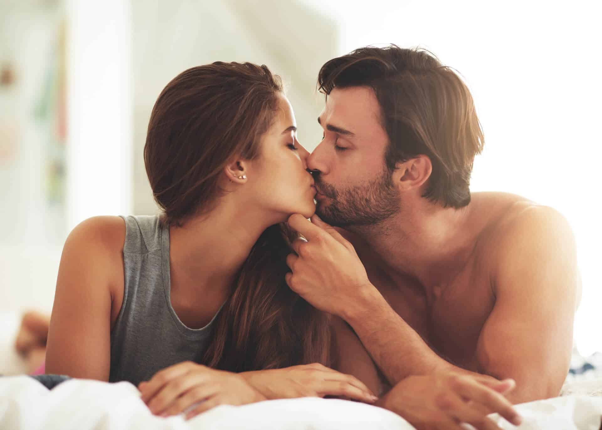 young affectionate couple kissing in bed