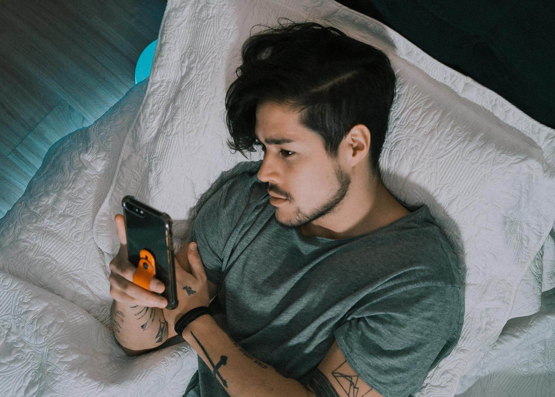 guy laying in bed with a phone