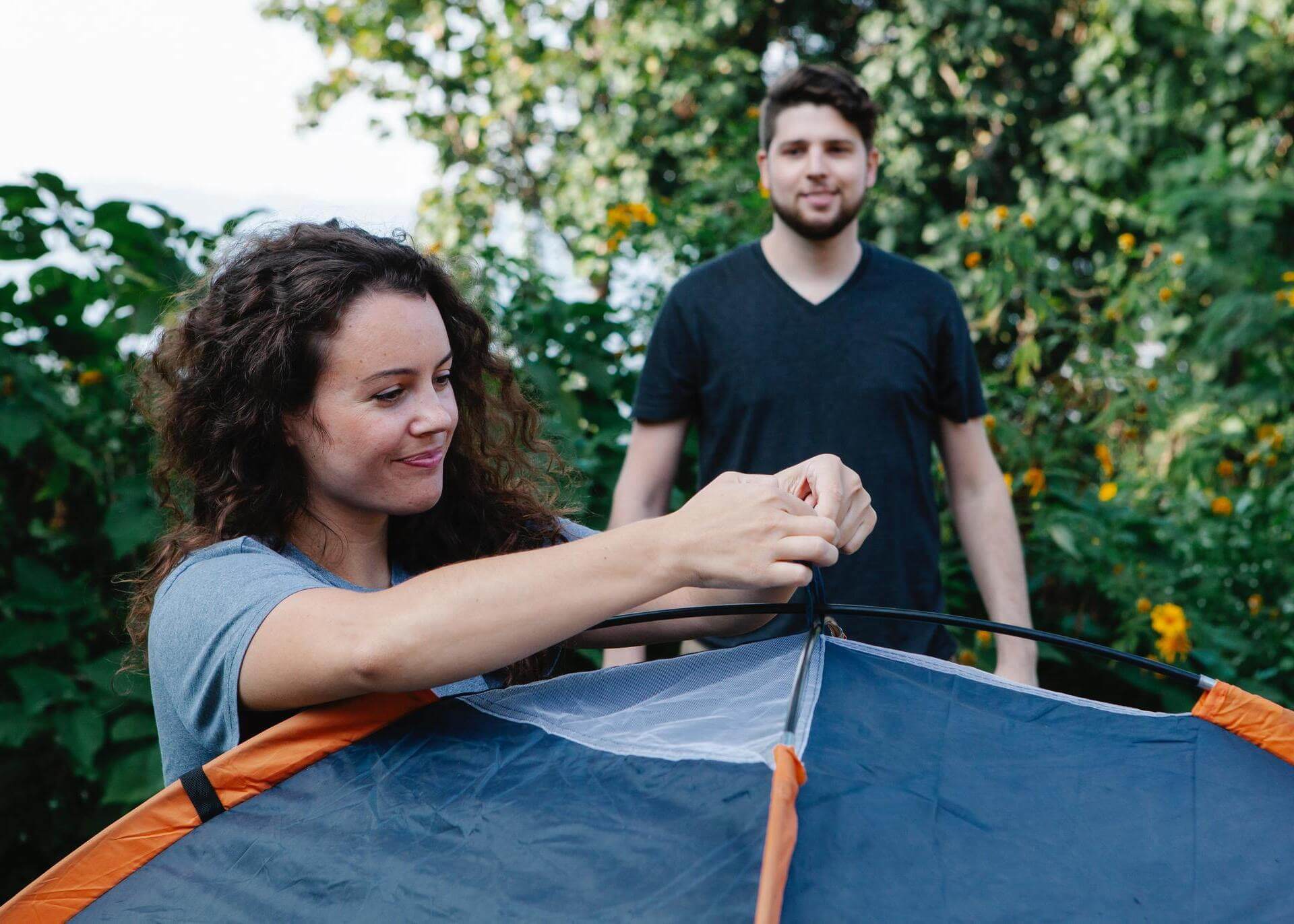 young couple setting up a tent