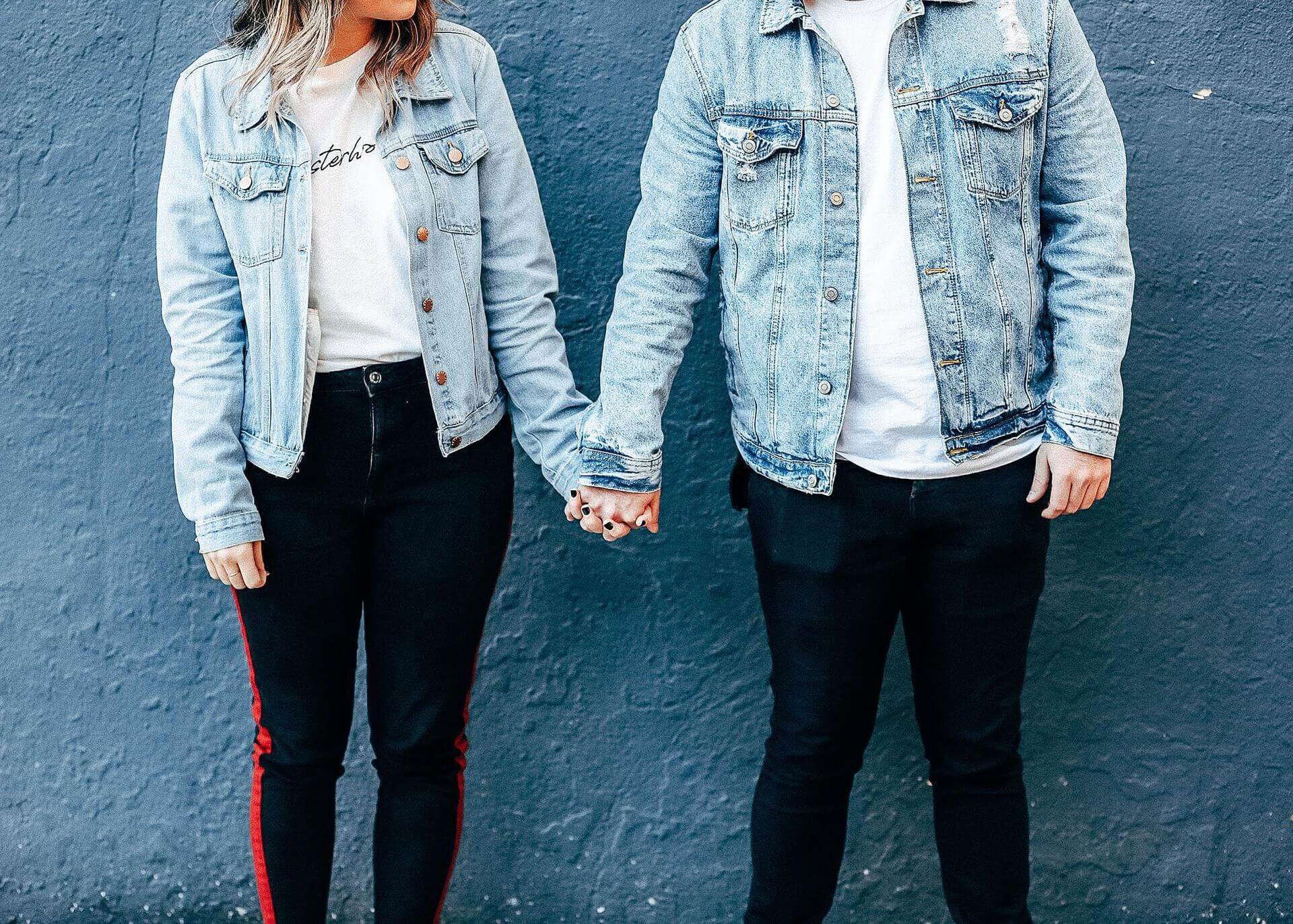 young couple in jean jackets holding hands