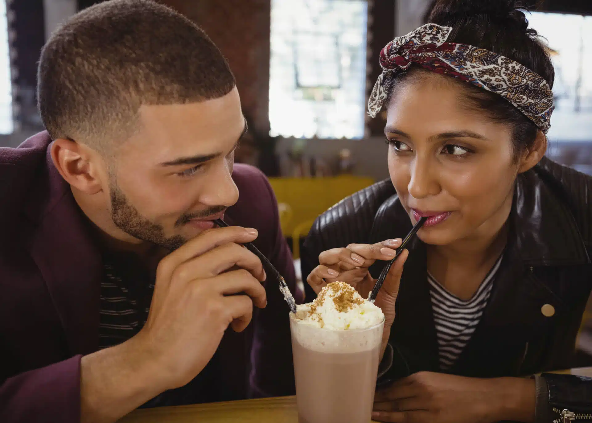 young couple sharing milkshake