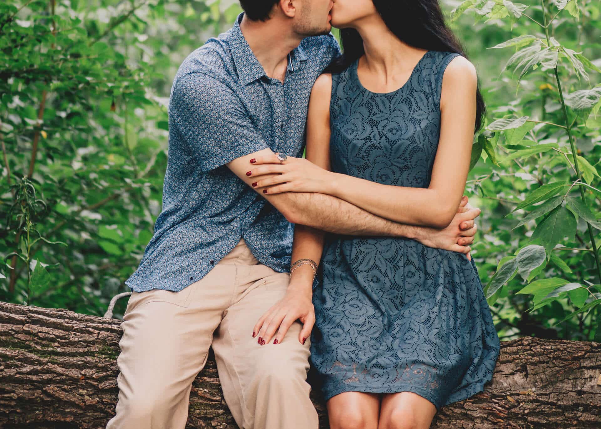 couple sitting on a tree kissing