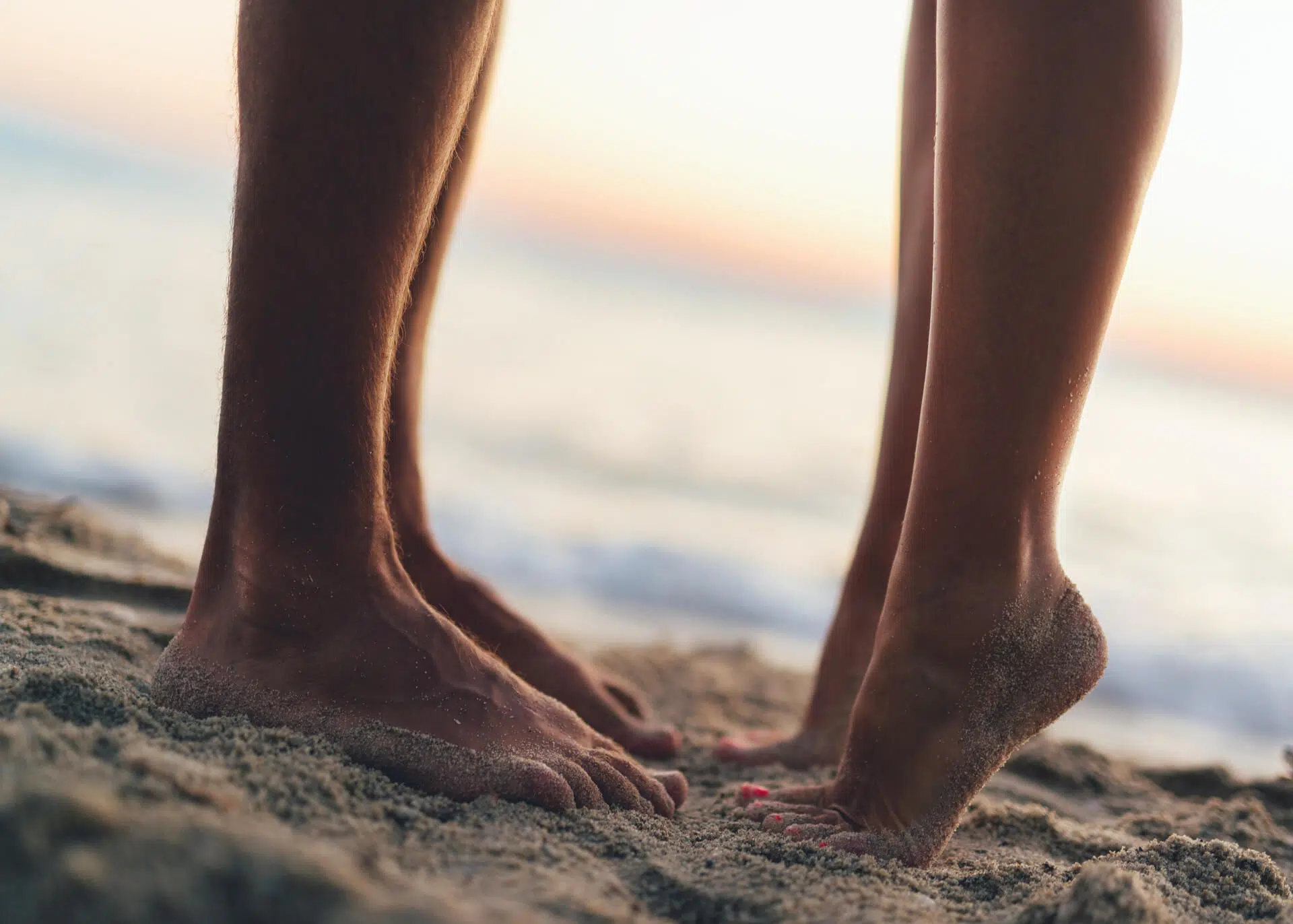 legs of two people kissing on the beach