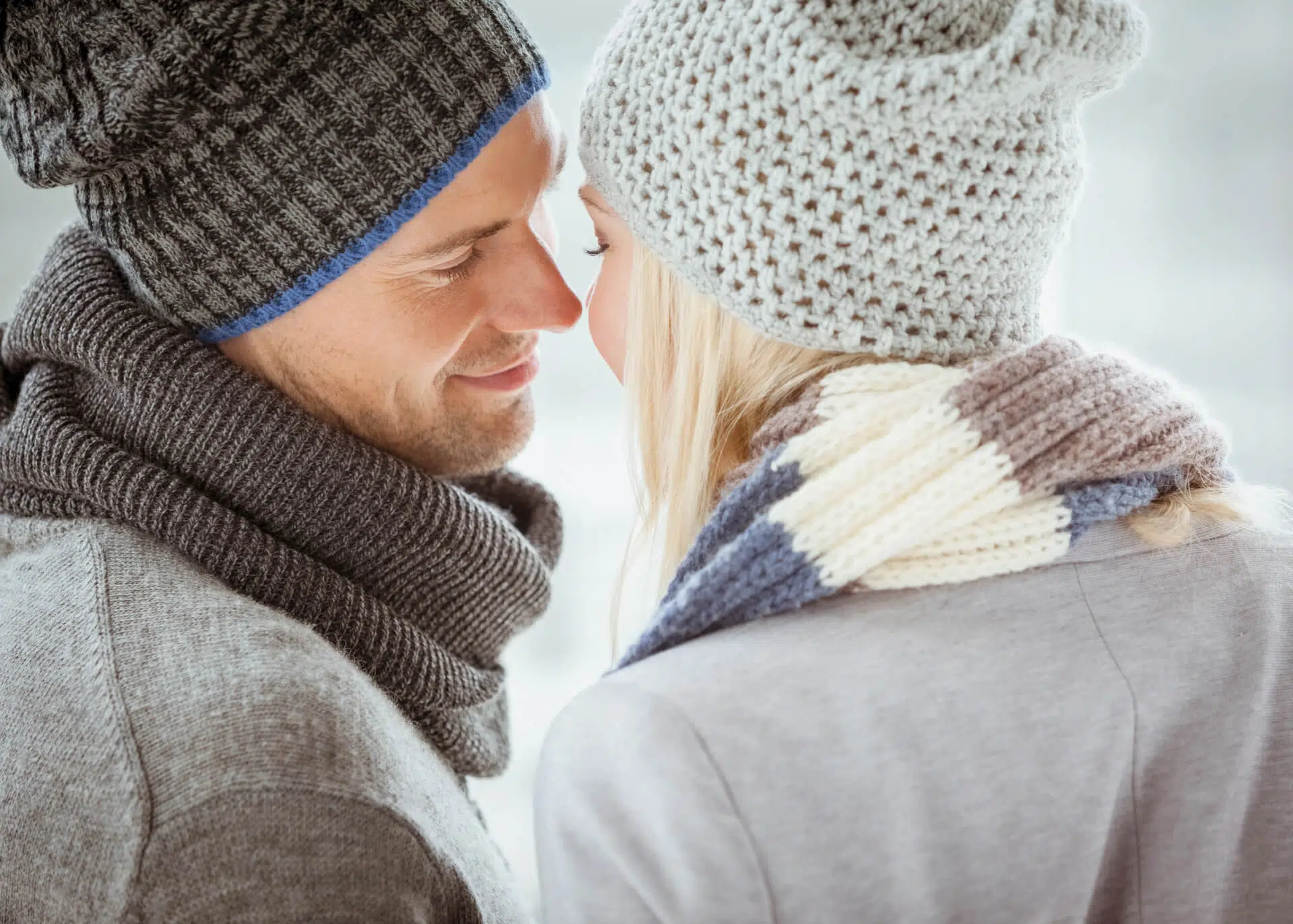 romantic couple in winter clothing looking at each other