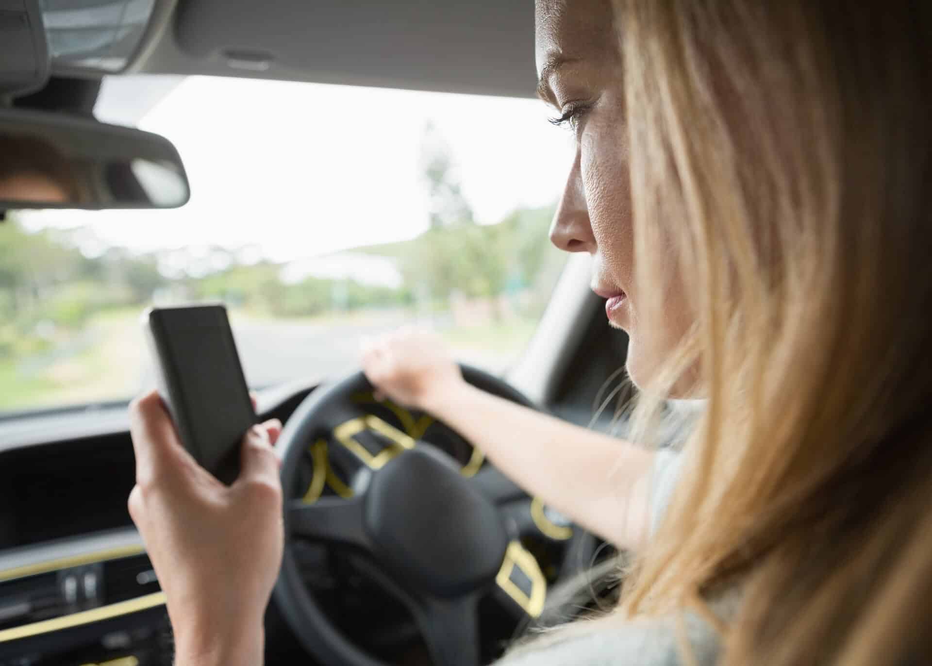 woman in car checking phone thinking why guys dont call when they like you
