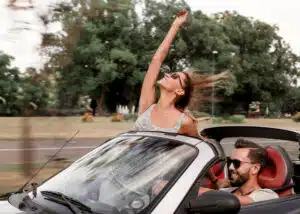 couple enjoying ride in a convertible car