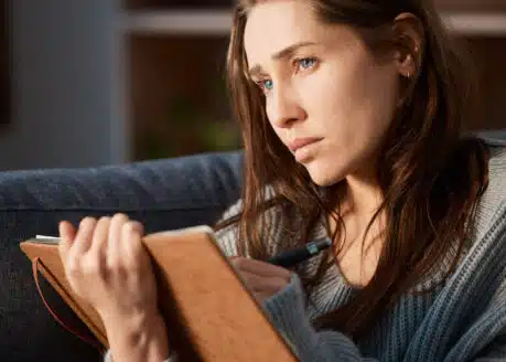 young sad woman writing a journal