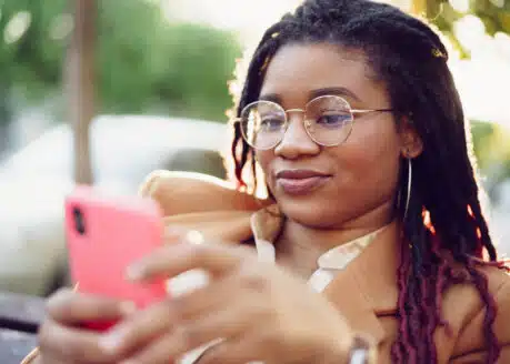 african american woman smiling while texting