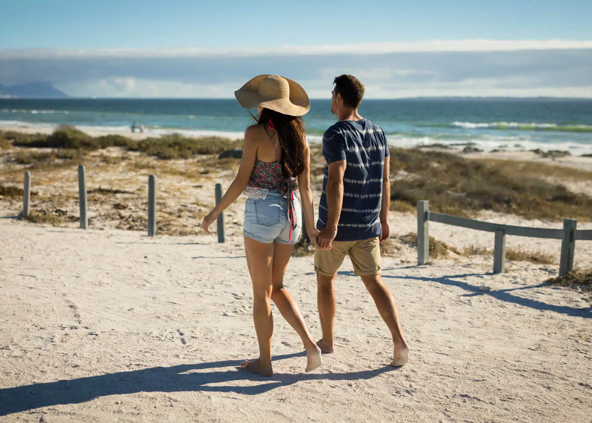 young couple walking by the sea holding hands