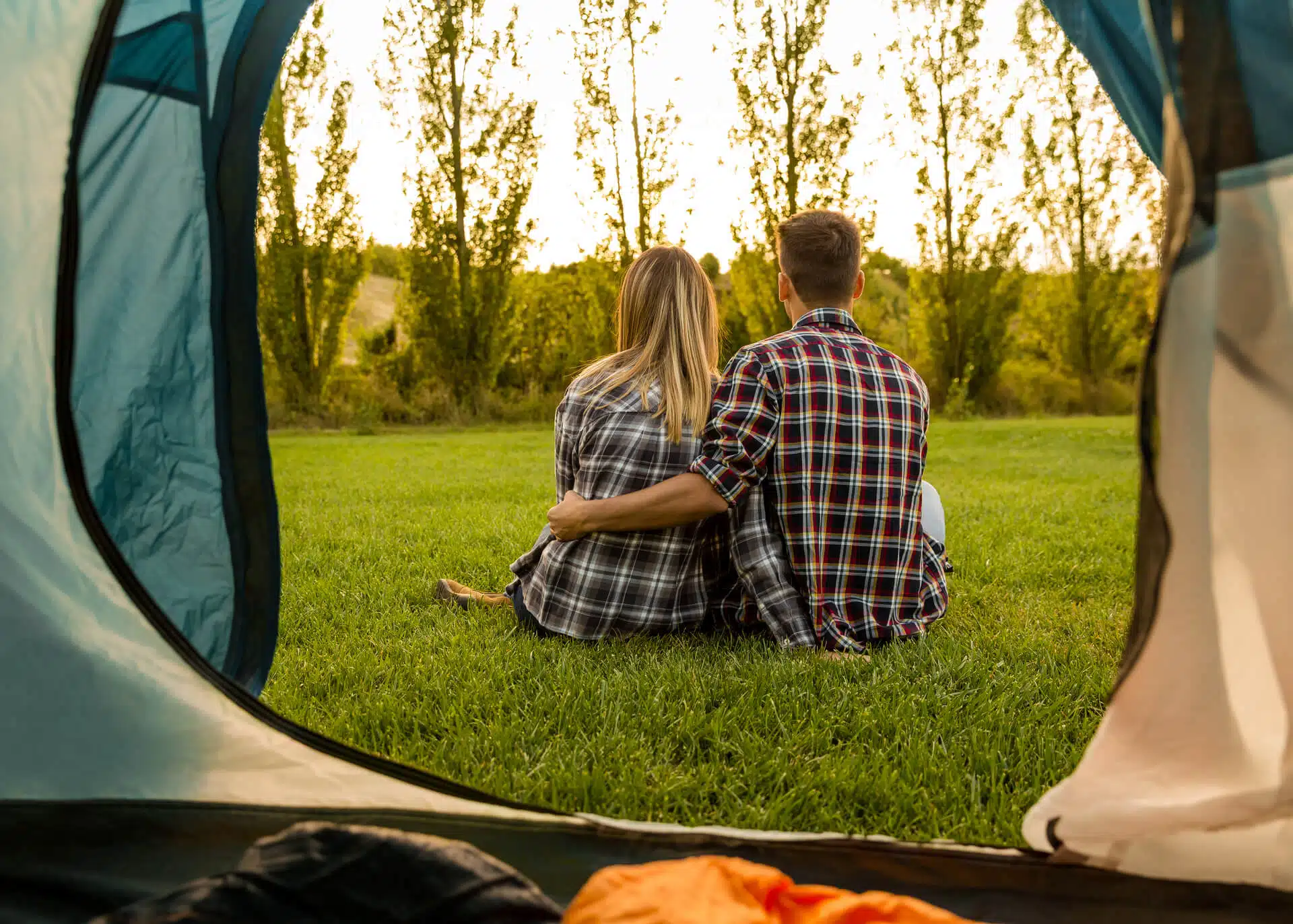 couple sitting outside the tent embracing