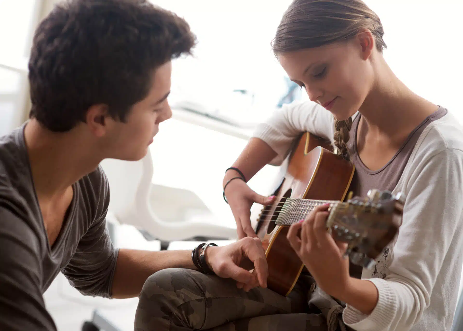woman playing guitar to her partner