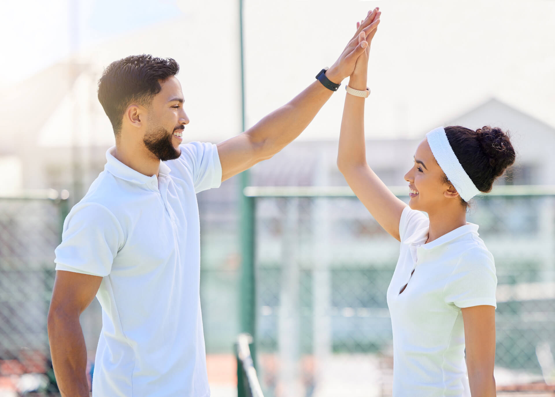 couple giving high five to each other after tennis match