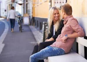 couple having conversation sitting on a bench