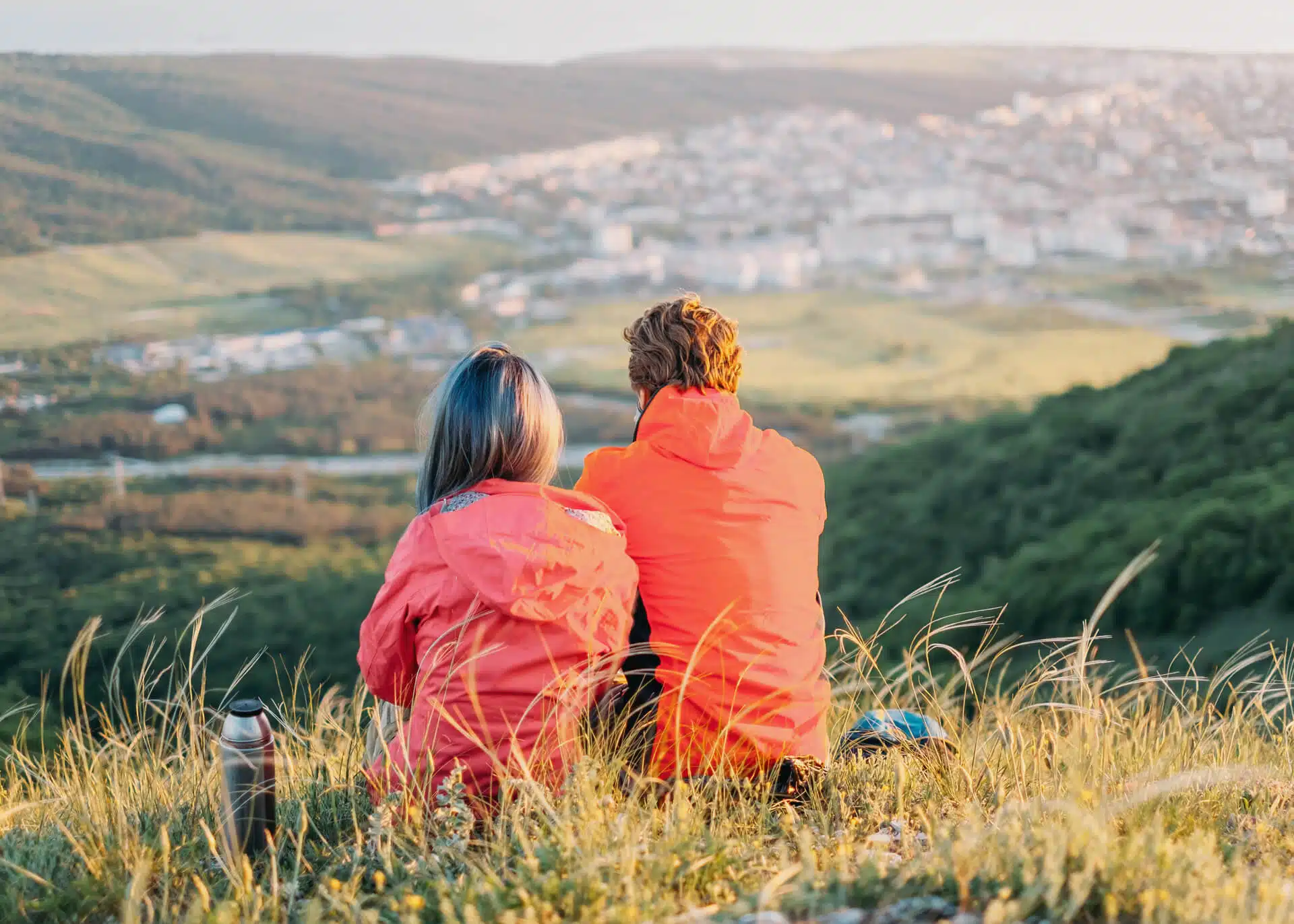 couple sitting in the mountains admiring scenery