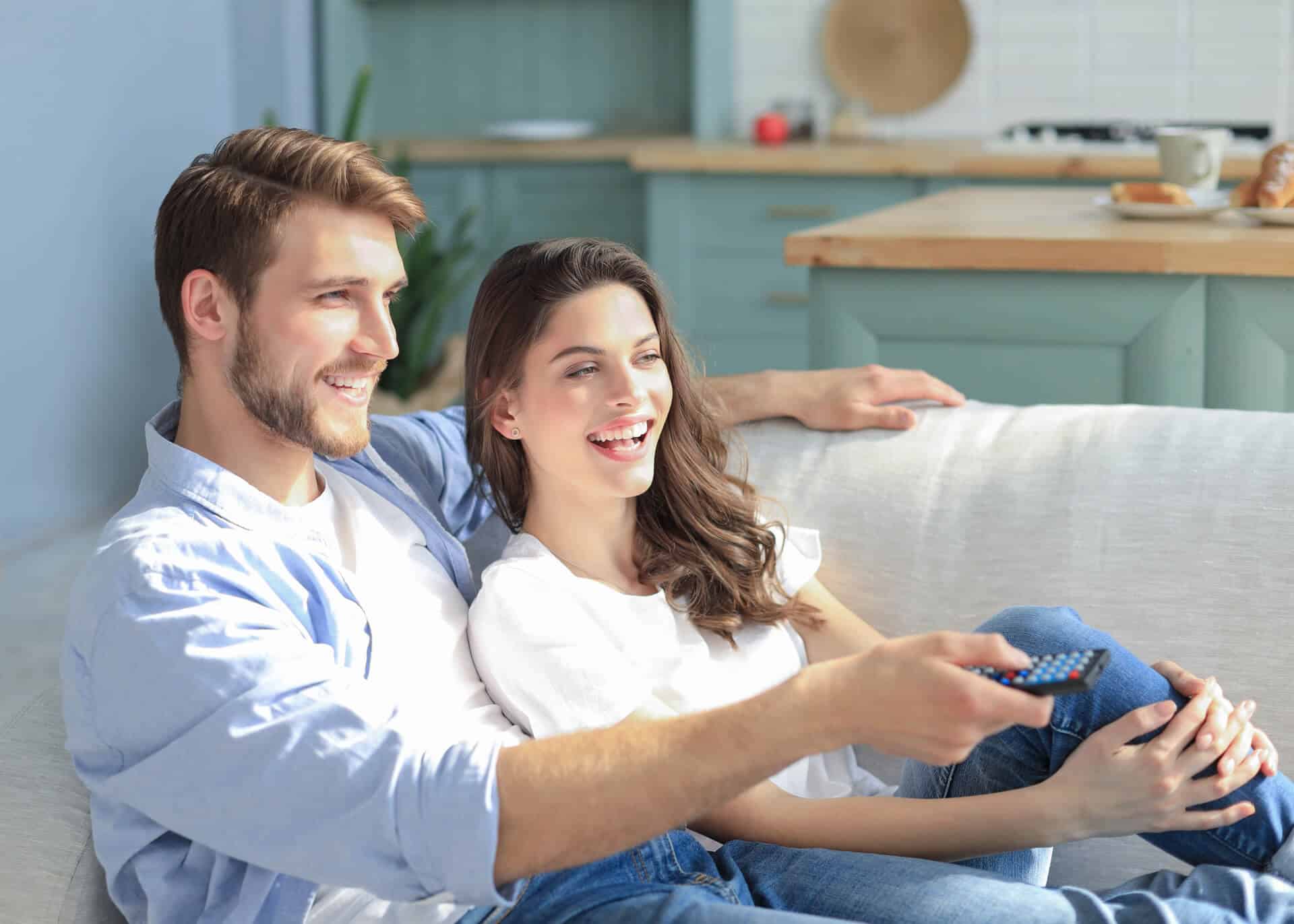 couple watching tv on the couch laughing