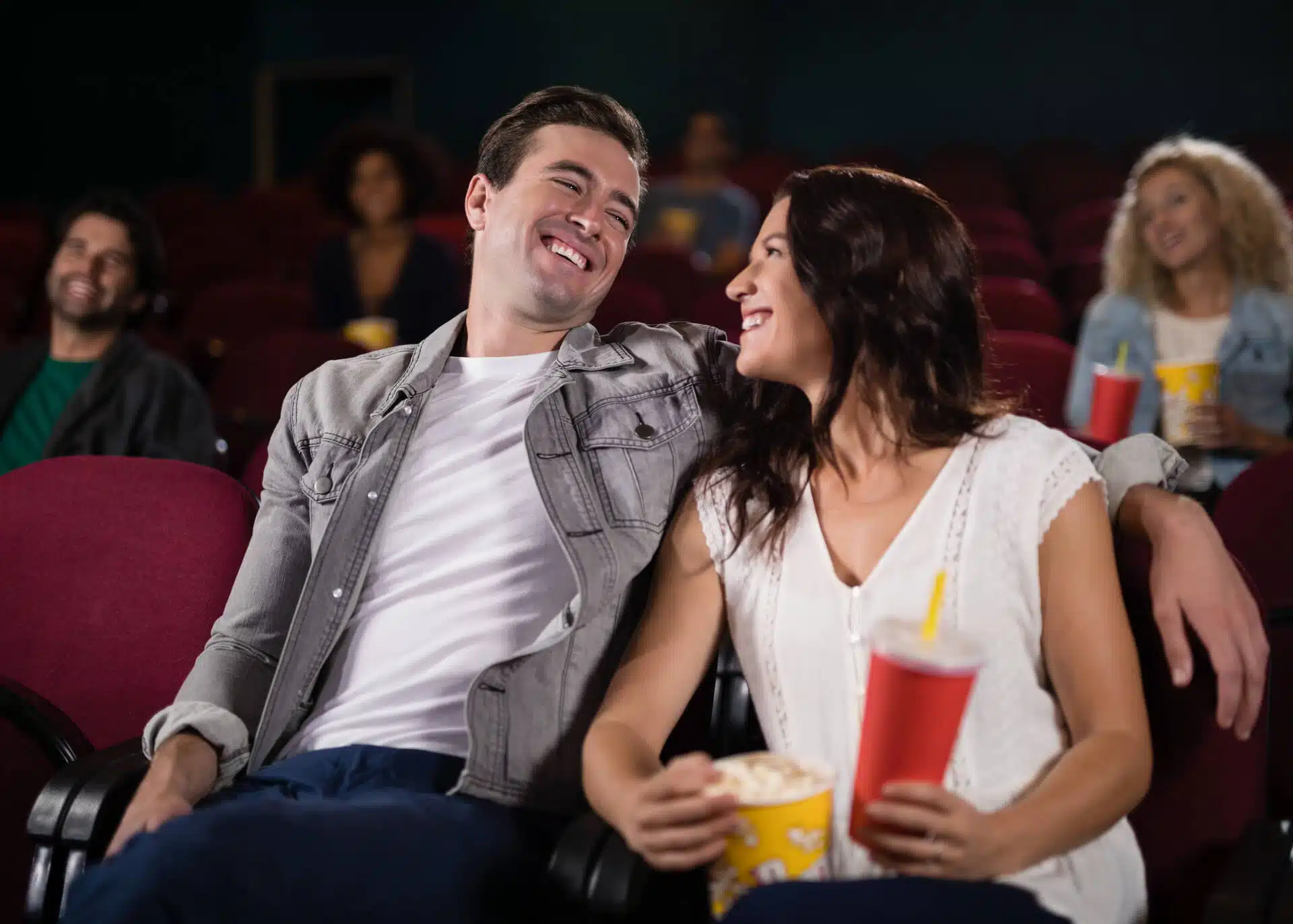 young couple lauging at a mpovie theatre