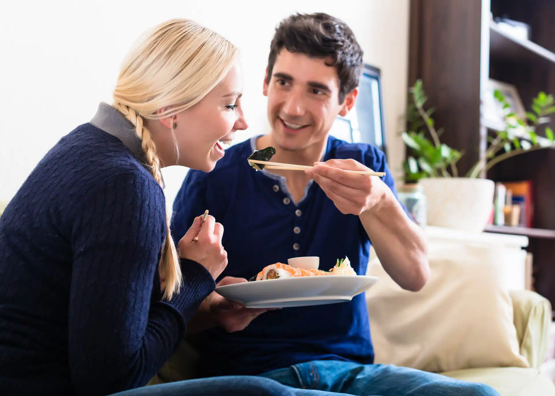 young man sharing sushi with his girlfriend