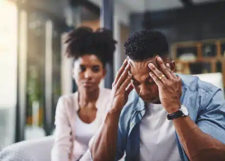 stressed man and a woman in the background