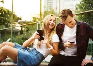young happy couple looking at their phones